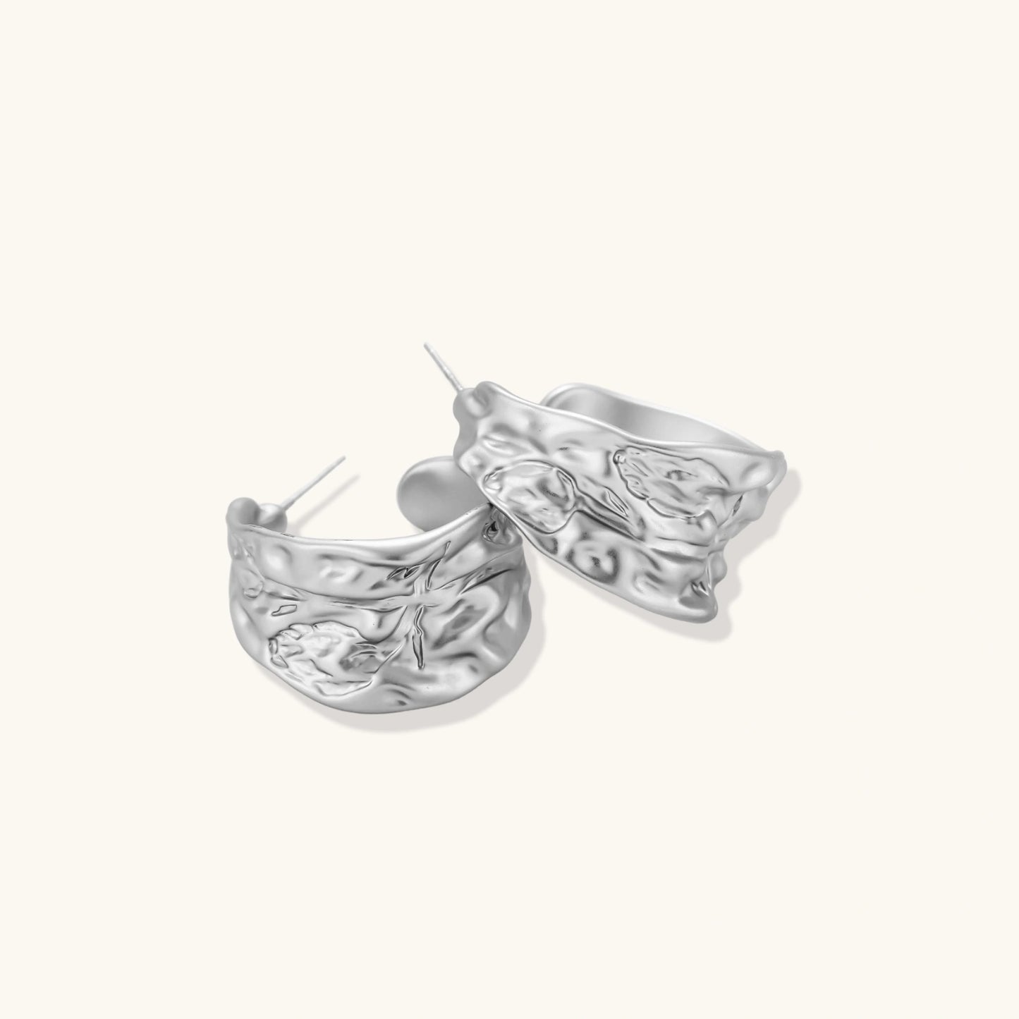 Close-up of textured hoop earrings with liquid metal ripple pattern in eco-zinc alloy with sterling silver posts.