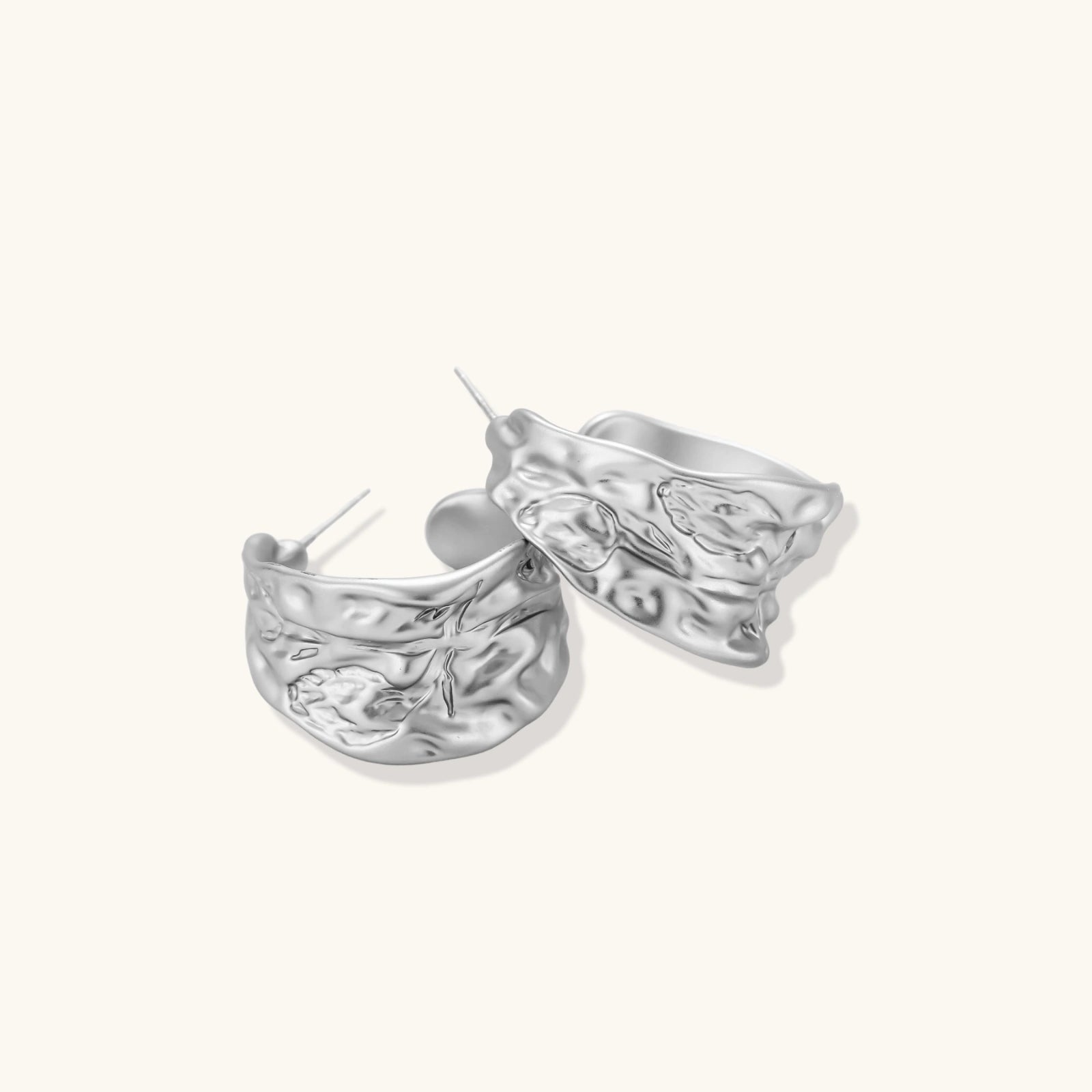 Close-up of textured hoop earrings with liquid metal ripple pattern in eco-zinc alloy with sterling silver posts.
